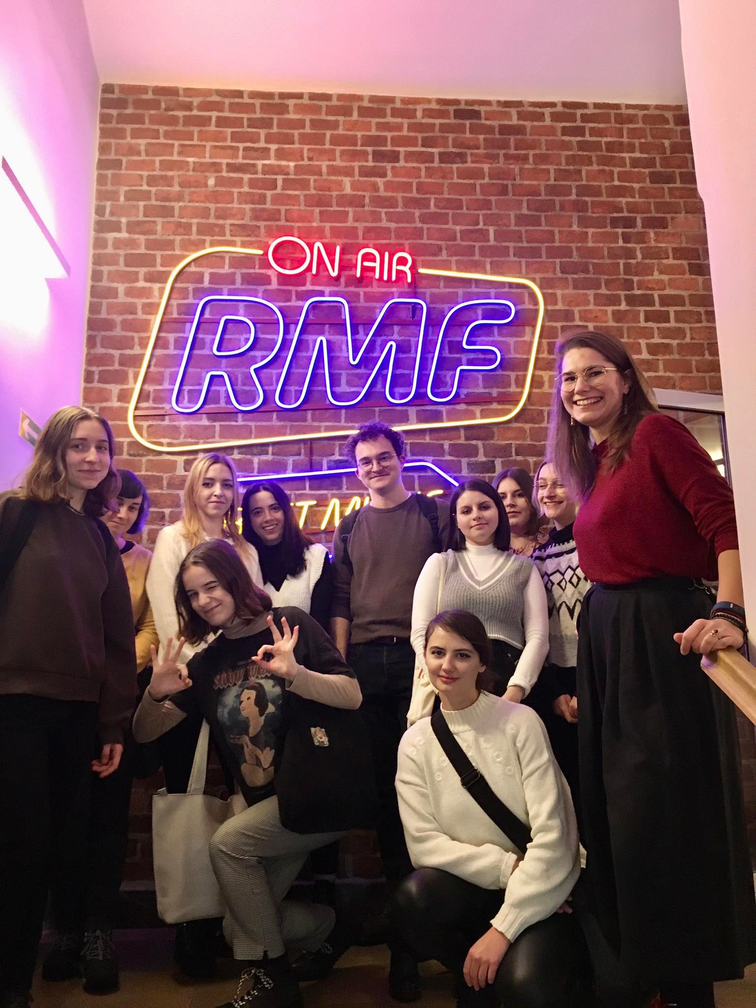 [Grafika: zdjęcie przedstawia grupę studentów oraz prowadzącą na tle napisu "On air RMF"]